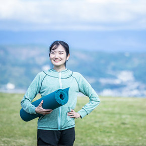 ヨガマットを持つ女性