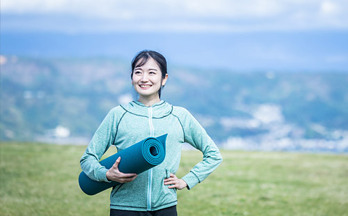 ヨガマットを持つ女性